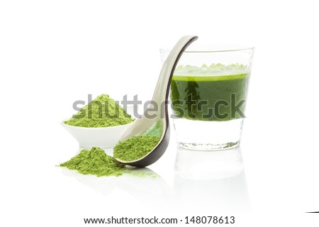 Green pills, green powder, green drink and wheat grass blades isolated on white background. Chlorella, spirulina, wheat grass and barley grass. Healthy natural herbal medicine, healthy lifestyle.