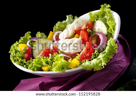 Luxurious colorful vegetable salad in bowl isolated on black background. Culinary gourmet eating.