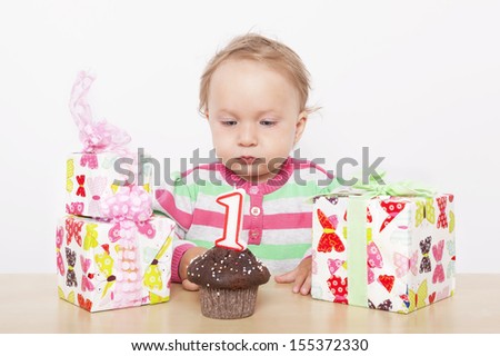 First birthday. Cute baby girl with birthday cake and birthday presents.