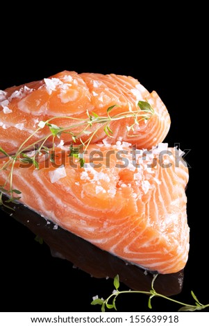 Luxurious salmon background. Fresh raw salmon piece isolated on black background. Culinary healthy fish eating.