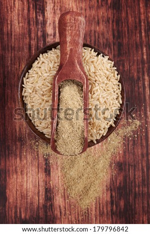 Dietary fiber. Rice in round wooden bowl with dietary rice fiber on dark brown wooden background, top view. Healthy eating concept.