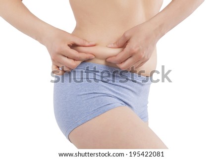 Beautiful caucasian girl in panties holding body fat isolated on white background. Weight loss and plastic surgery.