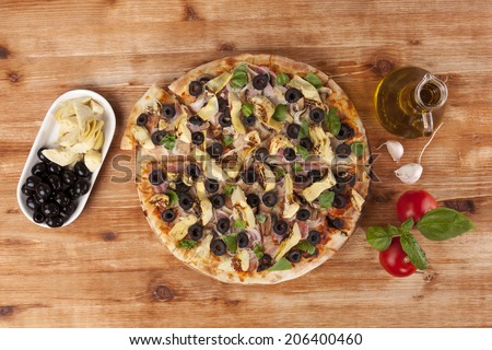 Pizza eating. Fresh pizza and fresh pizza ingredients on wooden table, top view. Italian pizza eating.
