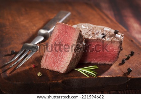 Juicy steak on dark wooden background. Luxurious mignon steak, rare. Culinary red meat eating.
