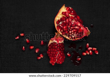 Luxurious pomegranate background. Pomegranate core on black background, top view. Healthy fruit eating.