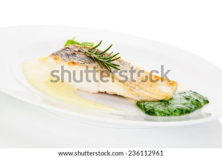 Delicious fish eating. Fresh perch fish fillet with potato and vegetable sauce on white plate isolated on white. Exquisite eating, fine gastronomy.