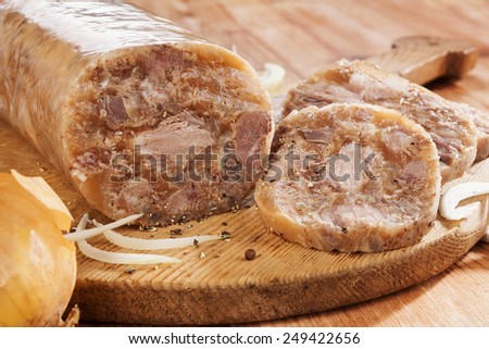 Head cheese cold cut vintage wooden background. Brawn with onion, garlic and bread on wooden vintage chopping board.