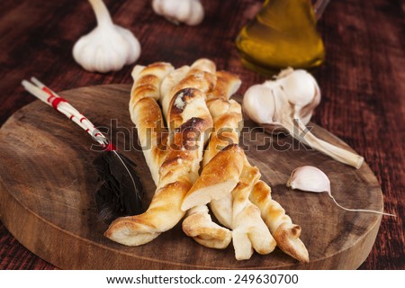 Pizza bread on round kitchen board on wooden kitchen table. Traditional pizza background.