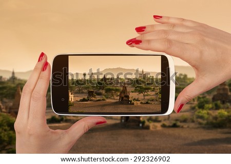 Bagan snapshot on smartphone screen in female hands with red nails. Female travel, vagabonding and backpacking.