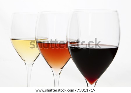 Three elegant crystal wine glasses with red, rose and white wine isolated on white background.