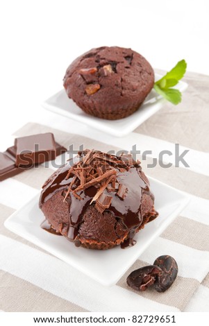 Delicious chocolate muffin with chocolate crop, fresh mint leaf and chocolate. Chocolate background.