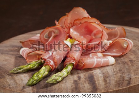 Delicious prosciutto slices with fresh asparagus. Culinary eating.