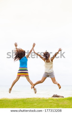Girls happy jump at the beach
