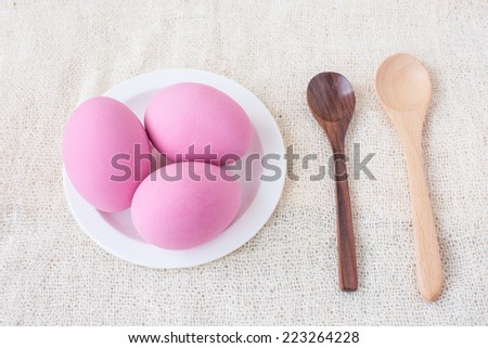 Preserved eggs with wooden spoons on white fabric