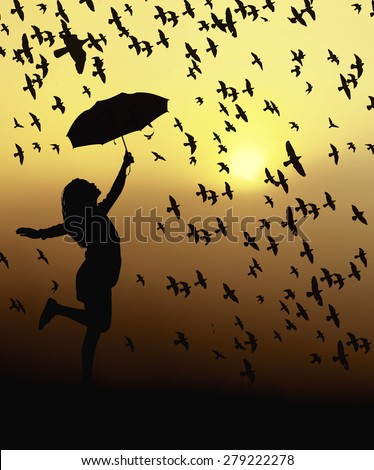 Silhouetted girl holding umbrella jumping at sunset, bird flying around