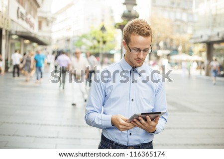 Businessman read news on Tablet Computer, urban street public space