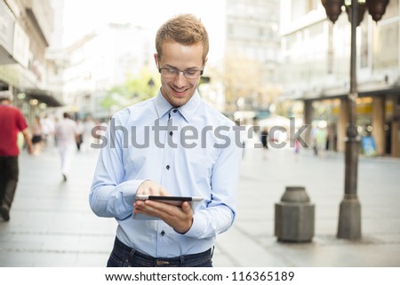 Man in Business suit using tablet computer in public space