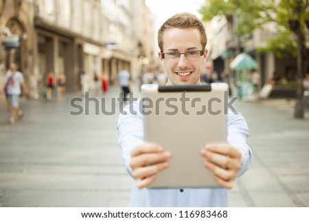 Businessman man hold tablet computer in public space
