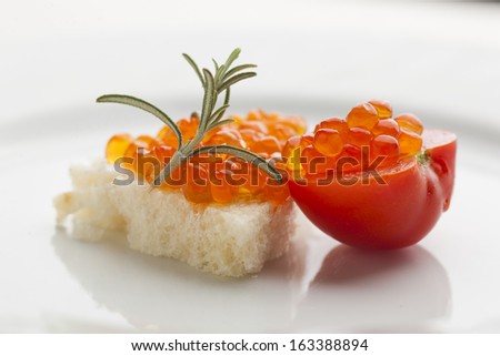 Perfect breakfast - Caviar sandwich with red cherry tomato on plate, decorated with rosemery