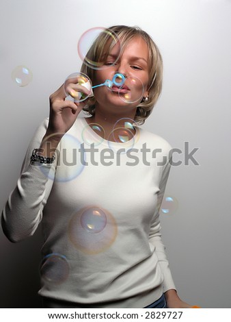 Young Woman Blowing Soap Bobbles, studio shot