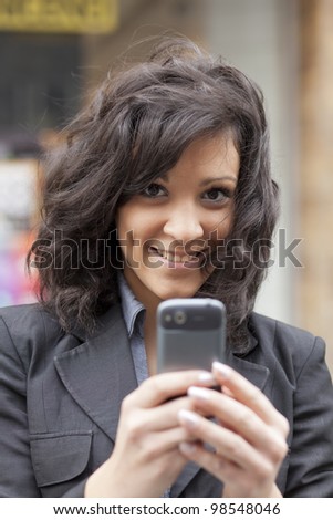 Young Woman with mobile phone walking background is blurred city