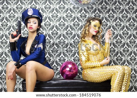 sexy policewoman watches over sexy jewel thief against vintage wallpaper