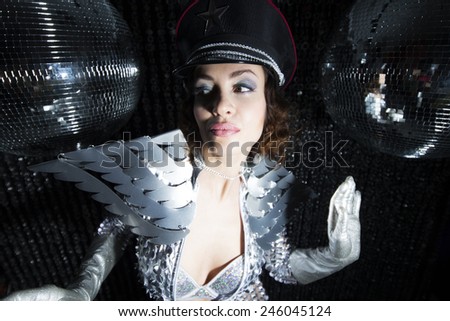 sexy disco party woman dressed in a unique silver costume with metal wings. Perfect for stylish club, disco and fashion events