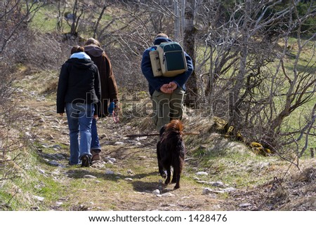 hikers with dog following trail in the french alps