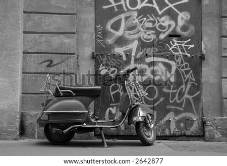 a scooter parked in front of a graphitti sprayed doorway in aix en provence south of france europe