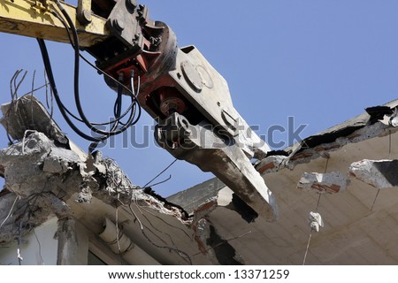 a crane breaking down a building, looking a bit like like a dinosaur eating!