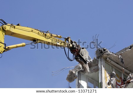 a crane breaking down a building, looking a bit like like a dinosaur eating!