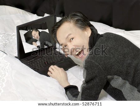 ethnic adult man having fun sharing photo on chat internet with laptop .