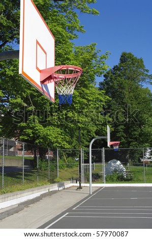 community outdoor basketball court with surrounding trees and sky prominent color blue grey white grey and red