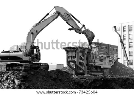 construction machinery excavator moving earth and demolition debris into a dumpster