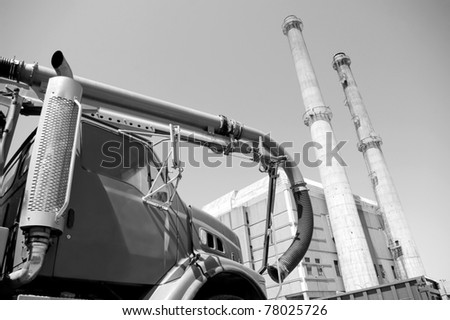 commercial service vehicle  foreground with industrial factory tower in background..
