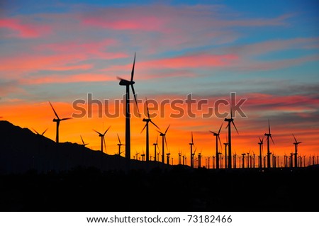 Power generating windmills against sunset