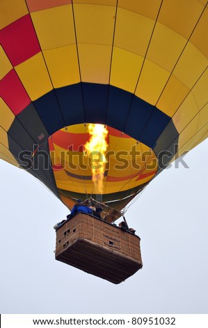 Close up of a hot air balloon in the sky with a basket full of people