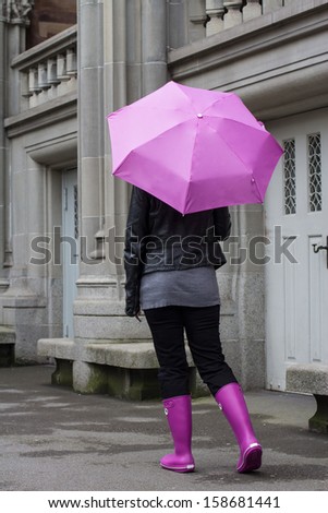 woman wearing a pink umbrella on a rainy day