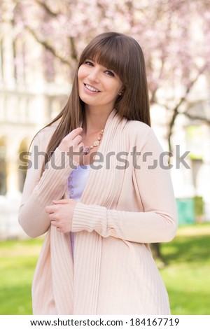 Young woman posing in pink cardigan sweater