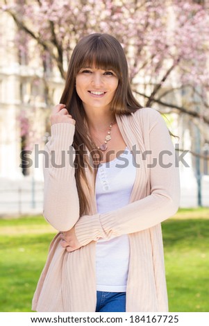 Happy young woman posing in pink cardigan sweater