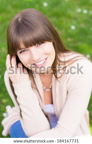 Happy woman stroking hair with hand  in pink cardigan sweater