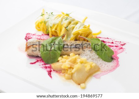 Pan broiled trout fillet with pasta, fresh basil, slices of pear and beetroot sauce.