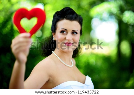 close-up portrait of a pretty shy bride with heart in hand