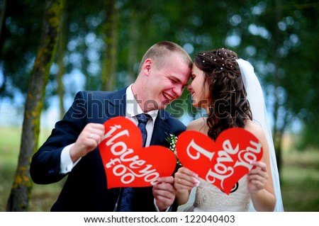 happy Groom and Bride in a park with signs I Love You . wedding dress. Love.