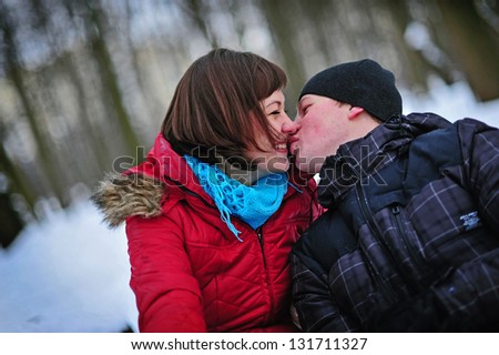Winter couple in snow smiling happy. Beautiful love young couple