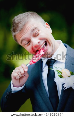 funny  groom licking and bite a lollipop