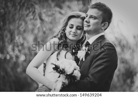 beautiful wedding couple in park. kiss and hug each other