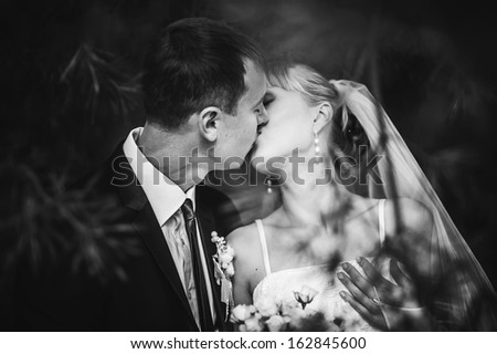 wedding couple hugging and kissing in a private moment of joy on a sunny autumn day