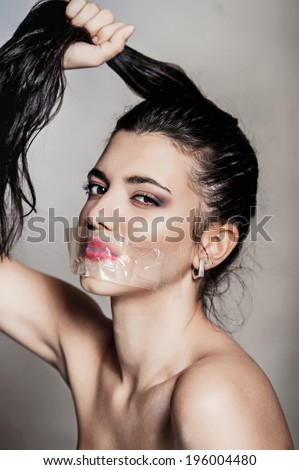 Portrait of beautiful brunette woman with glued mouth. Fashion shot.