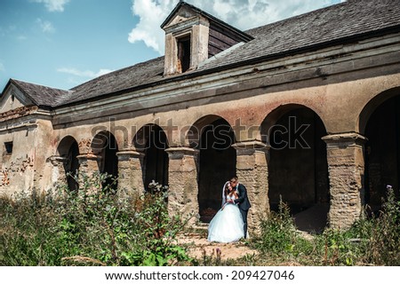 wedding couple hugging and kissing in a private moment near old building